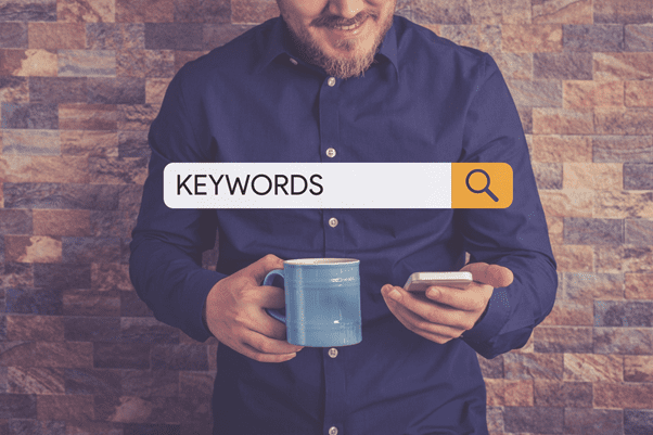 Man looking up the meaning of keywords on mobile - marketing consultant