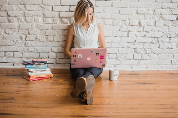 girl working on laptop sitting on the floor